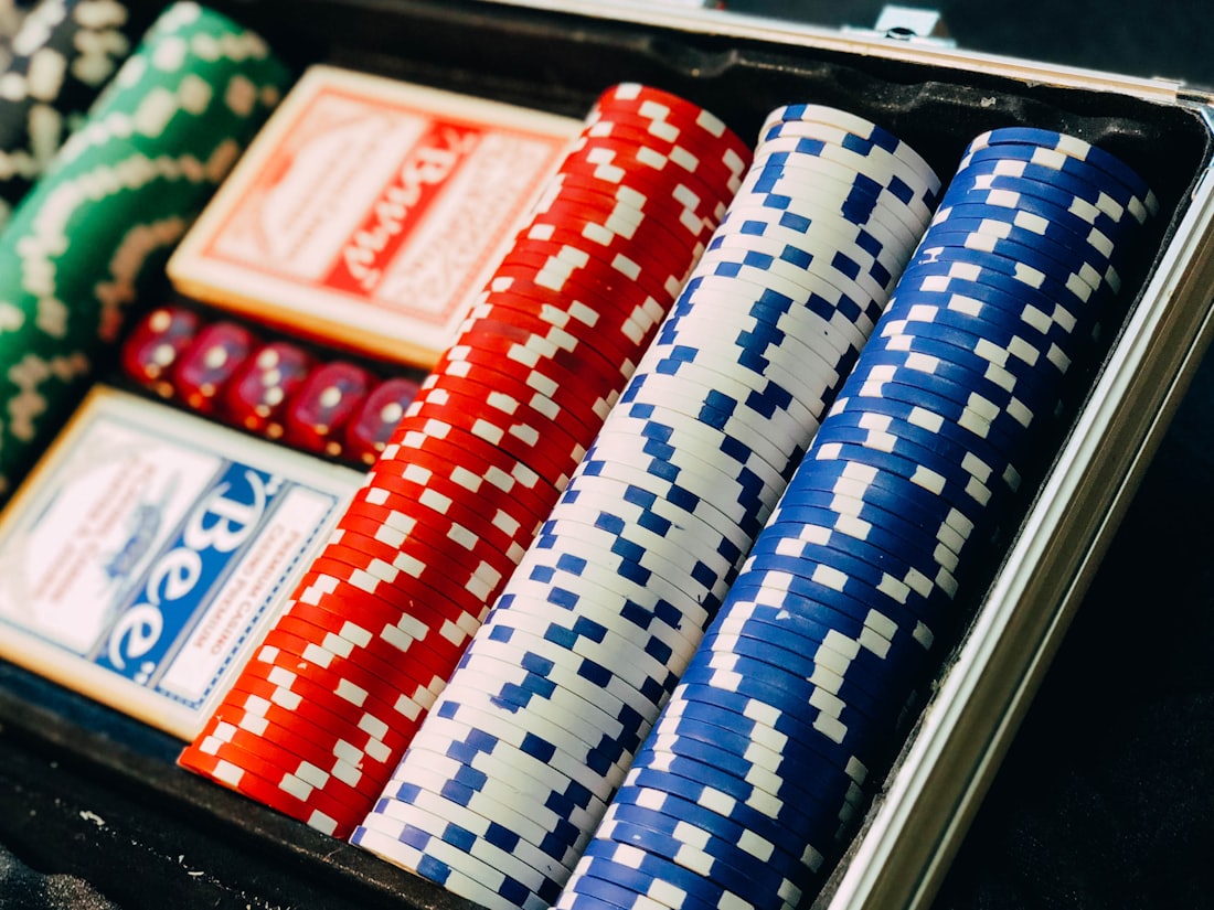 Satu set keping poker dan kartu remi tertata di dalam kotak